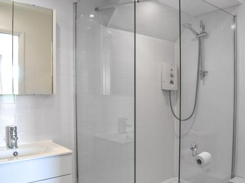 a white bathroom with a shower and a sink at The Hayloft - Uk46186 in St Margarets at Cliff