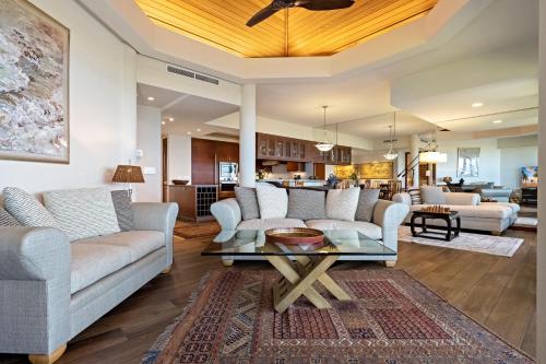 a living room with couches and a table at Mauna Lani Point in Waikoloa