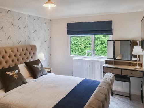 a bedroom with a bed and a desk and a window at Acre Hill Lodge in Harrop Fold