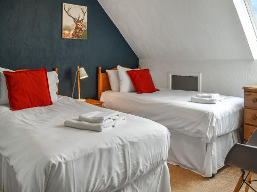a bedroom with two beds with red and white pillows at The Granary - Uk46187 in St Margarets at Cliff