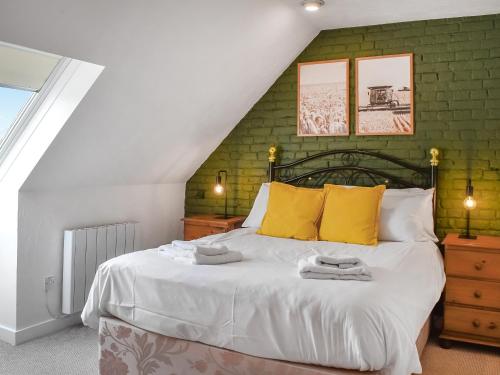 - une chambre avec un grand lit et des oreillers jaunes dans l'établissement The Dairy - Uk46188, à St Margarets at Cliff