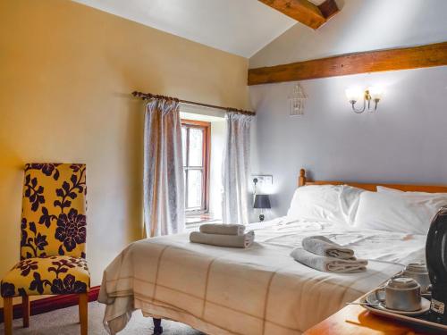 a bedroom with a bed and a chair and a window at Hopley House in Middlewich