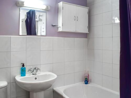 La salle de bains blanche est pourvue d'un lavabo et d'un miroir. dans l'établissement Hopley House, à Middlewich