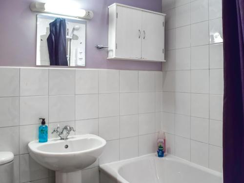 a white bathroom with a sink and a mirror at Hopley House in Middlewich