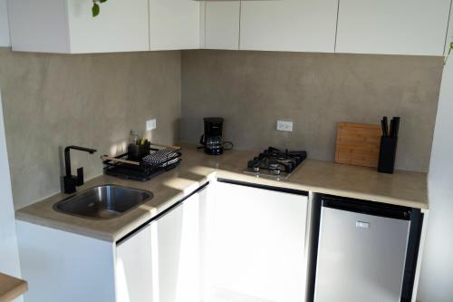 a kitchen counter with a sink and a stove at Alma Tropical - Luxury Villa Experience in Santa Teresa in Santa Teresa Beach