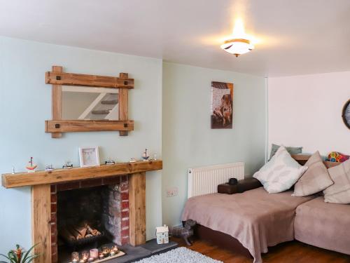 a living room with a bed and a fireplace at Chapel Street Cottage in Amlwch