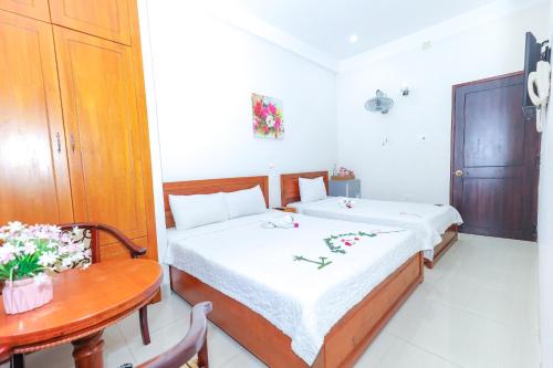 um quarto com duas camas e uma mesa e uma mesa em Khách sạn Ciao Quy Nhơn em Quy Nhon