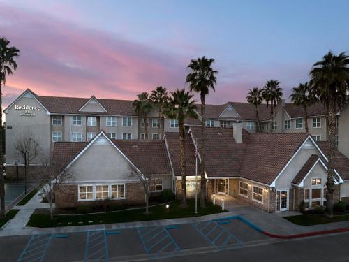 a hotel with palm trees in front of a building at Residence Inn by Marriott San Bernardino in San Bernardino