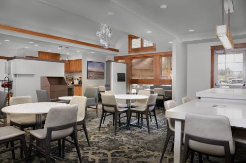 a dining room with tables and chairs and a kitchen at Residence Inn by Marriott San Bernardino in San Bernardino