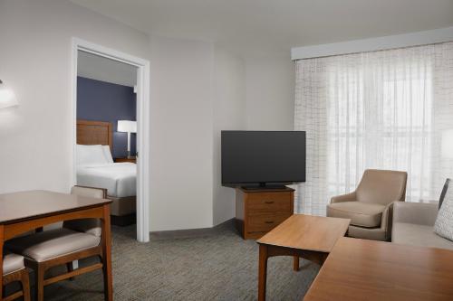 a hotel room with a television and a bed at Residence Inn by Marriott San Bernardino in San Bernardino
