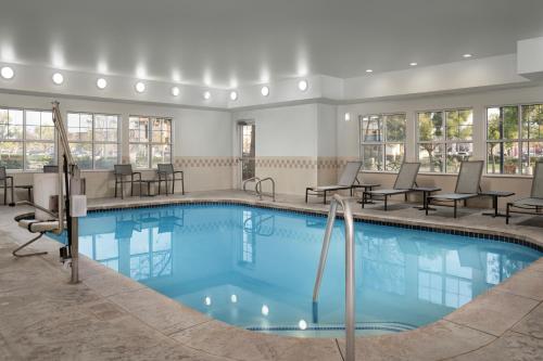 a pool in a hotel room with tables and chairs at Residence Inn by Marriott San Bernardino in San Bernardino