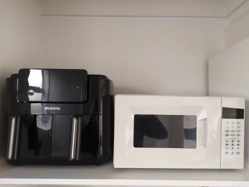 a microwave and a coffee maker next to each other at Alexander Motel in Taumarunui