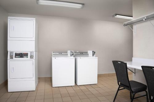 two white refrigerators in a room with a table and chairs at Residence Inn by Marriott San Bernardino in San Bernardino
