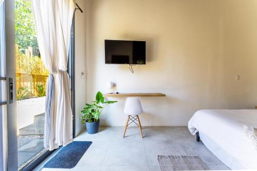 a bedroom with a bed and a desk and a tv at Alma Tropical - Luxury Villa Experience in Santa Teresa in Santa Teresa Beach