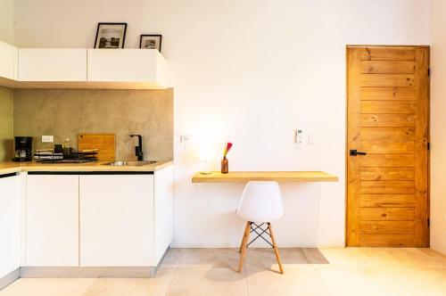a kitchen with white cabinets and a wooden door at Alma Tropical - Luxury Villa Experience in Santa Teresa in Santa Teresa Beach