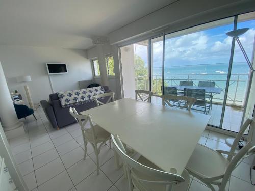 - un salon avec une table et des chaises et une vue sur l'océan dans l'établissement Appartement T3 en bord de mer avec balcon, WIFI et parking sécurisé - FR-1-374-23, à Arcachon