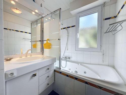 La salle de bains blanche est pourvue d'une baignoire et d'un lavabo. dans l'établissement Appartement Granville, 3 pièces, 4 personnes - FR-1-361-161, à Granville