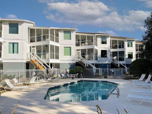 a large apartment building with a swimming pool in front at The Moorings Condo - Wild Dunes Resort - Isle of Palms Marina in Isle of Palms