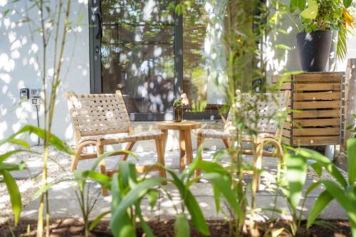 two chairs and a table on a patio with plants at Alma Tropical - Luxury Villa Experience in Santa Teresa in Santa Teresa Beach