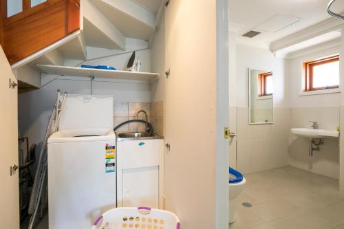 a small kitchen with a refrigerator and a sink at Nightcap at the Ship Inn in Busselton