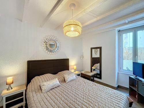1 dormitorio con 1 cama grande y TV en Appartement Lamalou-les-Bains, 2 pièces, 2 personnes - FR-1-451-202 en Lamalou-les-Bains