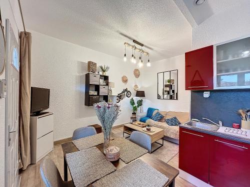 Il dispose d'une cuisine et d'un salon avec un canapé et une table. dans l'établissement Appartement F2 avec terrasse, climatisation et proche des Thermes - Lamalou-les-Bains - FR-1-451-202, à Lamalou-les-Bains