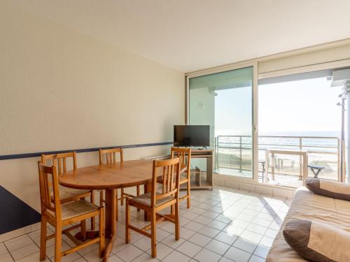 une salle à manger avec une table, des chaises et une télévision dans l'établissement Mimizan Plage: Appartement 6 pers. avec balcon et parking - FR-1-50-114, à Mimizan