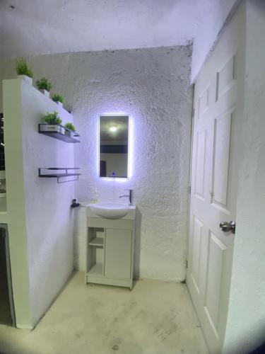 a white bathroom with a sink and a mirror at Depa Santa María in Malinalco