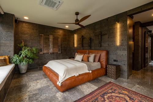 a bedroom with a large bed in a brick wall at Samanvaya - Adults Only in Sidemen