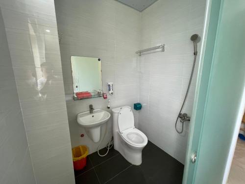 a bathroom with a toilet and a sink and a mirror at Việt Nga Hotel - Chợ Côn Đảo in Con Dao