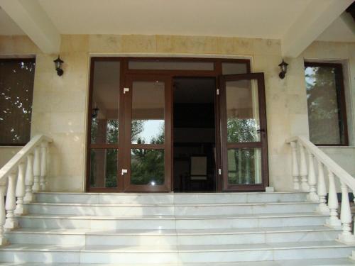 an entrance to a house with glass doors and stairs at Hotel Villa Ofir in Sandanski