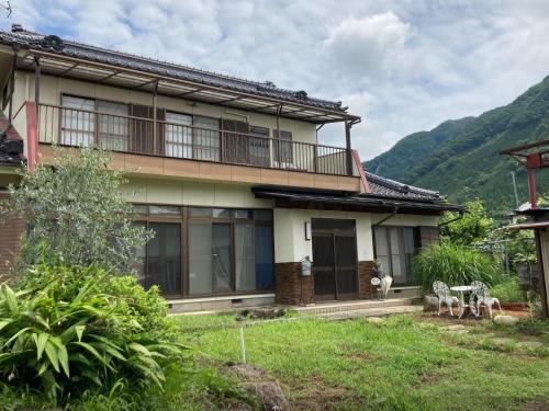 uma casa com uma varanda e uma montanha em B&B Ladies Only Grape mama Grape room - Vacation STAY 11649 em Koshu