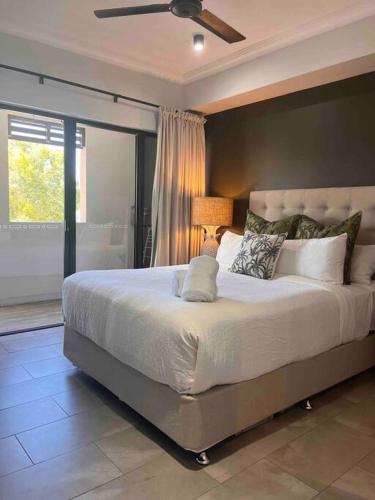 a bedroom with a large bed with a ceiling fan at Luxury marina view Apartment cairns in Trinity Beach