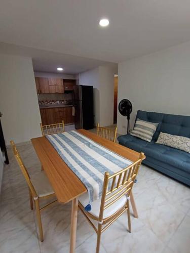 a living room with a wooden table and a blue couch at Agradable y Económico Apartamento in Santa Fe de Antioquia