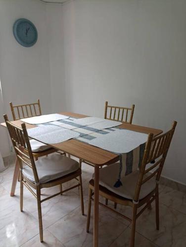 聖菲－安蒂奧基亞的住宿－Agradable y Económico Apartamento，餐桌、四把椅子、一张桌子和闹钟