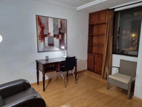 een woonkamer met een bureau en een stoel bij Advocatus’ Flat in Cuenca