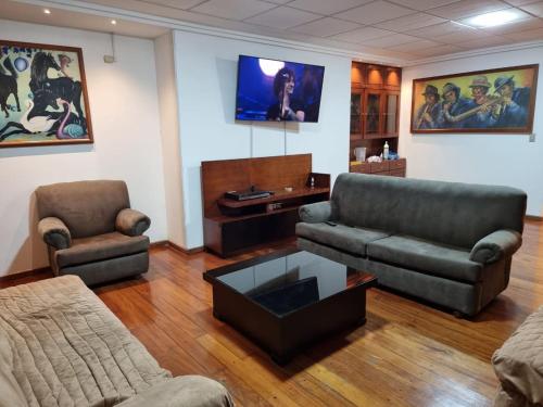 een woonkamer met 2 banken en een tv bij Advocatus’ Flat in Cuenca