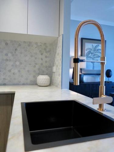 a kitchen counter with a sink and a sink at Luxury marina view Apartment cairns in Trinity Beach