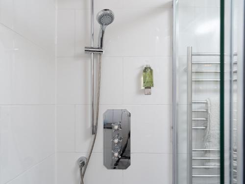 a shower in a white bathroom with a shower at The Barn Annexe in St. Just
