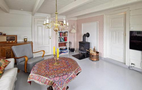 a living room with a table and a chandelier at 3 Bedroom Cozy Home In Farsund in Farsund
