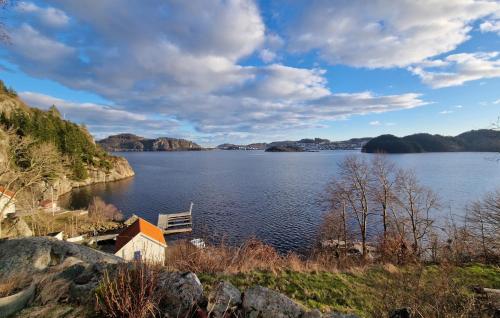 a view of a lake with a bench on the shore at 3 Bedroom Cozy Home In Farsund in Farsund
