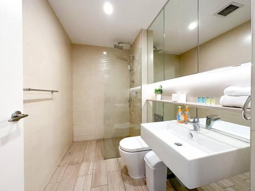 La salle de bains est pourvue d'un lavabo, de toilettes et d'un miroir. dans l'établissement City Living Made Easy : 1 Bed Apt in Ashfield Heart, à Sydney