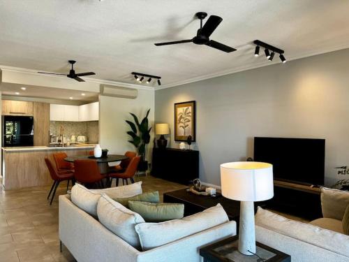 a living room with a couch and a dining room at Bluewater Apartment in Trinity Beach