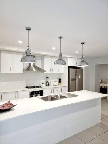 a white kitchen with white cabinets and a sink at 5-Bedroom House: Ensuite, Netflix, Prime Location in Waterford