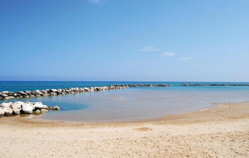 a sandy beach with rocks in the water at Amazing Apartment In Montefelcino in Montefelcino