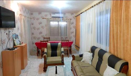 - un salon avec un canapé et une table à manger dans l'établissement Château angele w&b, à Lomé