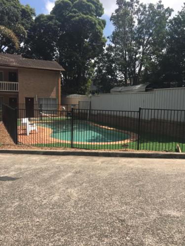 a black fence in front of a house at Sutherland Motel in Sutherland