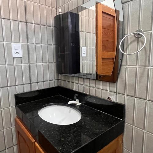 a bathroom with a sink and a mirror at Suíte completa em Parintins in Parintins