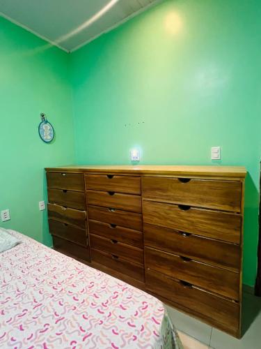 a bedroom with a large wooden dresser and a bed at Suíte completa em Parintins in Parintins