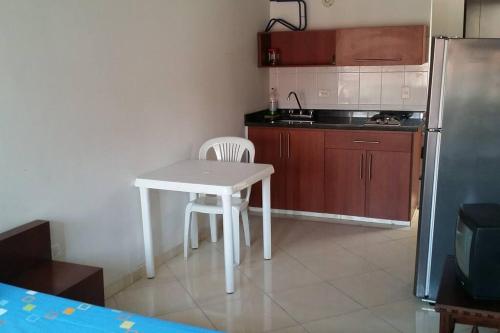 a small kitchen with a white table and a refrigerator at Aparta-estudio amoblado 202, 2p, wifi in Socorro